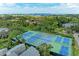 An aerial view of the six tennis courts among lush landscaping and residences at 264 Woods Point Rd, Osprey, FL 34229
