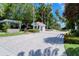 Landscaped entrance to Tangerine Bay Club with guard house, mature palms, and brick-paved drive at 380 Gulf Of Mexico Dr # 513, Longboat Key, FL 34228