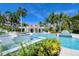 Resort-style pool with a central bar area, surrounded by lush landscaping and palm trees at 380 Gulf Of Mexico Dr # 513, Longboat Key, FL 34228