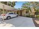 Exterior of home featuring attached carport, spacious driveway, and lush tropical landscaping at 5071 Village Gardens Dr # 5, Sarasota, FL 34234