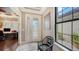 Bright entryway with hardwood floors, a charming chair, and a view into an adjacent office at 12663 Fontana Loop, Bradenton, FL 34211