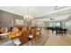 Formal dining room with a large wooden table, chandelier, and piano at 12663 Fontana Loop, Bradenton, FL 34211