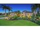 Single-Gathering home with a beautifully landscaped yard and palm trees at dusk at 12663 Fontana Loop, Bradenton, FL 34211