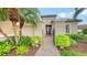 Elegant entryway with a paver walkway, lush landscaping, and a decorative gate at 12663 Fontana Loop, Bradenton, FL 34211
