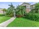 Tan two-story condo with lush landscaping and a walkway at 8905 Manor Loop # 205, Lakewood Ranch, FL 34202