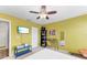 Bedroom with yellow walls, ceiling fan, and a built-in shelving unit at 8905 Manor Loop # 205, Lakewood Ranch, FL 34202