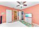 Bedroom with coral walls, ceiling fan, and en-suite bathroom access at 8905 Manor Loop # 205, Lakewood Ranch, FL 34202