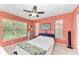 Bright bedroom with coral walls, ceiling fan, and large windows at 8905 Manor Loop # 205, Lakewood Ranch, FL 34202