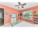 Bedroom with coral walls, ceiling fan, window, and a dresser at 8905 Manor Loop # 205, Lakewood Ranch, FL 34202