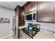 Modern kitchen with granite countertops, stainless steel appliances, and dark wood cabinets at 8905 Manor Loop # 205, Lakewood Ranch, FL 34202