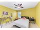 Bedroom with yellow walls, ceiling fan, and a workspace at 8905 Manor Loop # 205, Lakewood Ranch, FL 34202