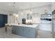 Modern kitchen with white and gray cabinets, a large island, and a pot rack at 229 Corelli Dr, Nokomis, FL 34275