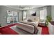 Spacious main bedroom with plush bed, access to sunroom, and red carpet at 5018 25Th E St, Bradenton, FL 34203
