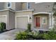 Townhouse with attached garage and a red front door at 5725 Haven Ter, Nokomis, FL 34275