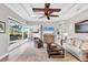A bright living room with sliding doors to the outside and decorative ceiling features at 14619 Leopard Creek Pl, Lakewood Ranch, FL 34202