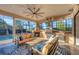 Relaxing screened-in outdoor space includes a fireplace, grill, stylish furniture, and pool access at 14619 Leopard Creek Pl, Lakewood Ranch, FL 34202