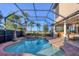 Gorgeous screened-in pool and spa area with an outdoor kitchen and green landscaping at 14619 Leopard Creek Pl, Lakewood Ranch, FL 34202