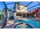 Backyard featuring a screened-in pool, spa, outdoor seating and lush tropical foliage at 14619 Leopard Creek Pl, Lakewood Ranch, FL 34202