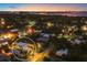 An aerial nighttime view showcases the property lit up, nestled among tree-lined streets near the bay at 1884 Grove St, Sarasota, FL 34239