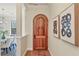 Inviting foyer boasts a striking arched wood door and stylish artwork enhancing its charm and character at 1884 Grove St, Sarasota, FL 34239