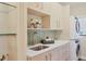 Well-appointed laundry room features shaker cabinets, shelving, modern appliances, tile backsplash, and quartz countertops at 1884 Grove St, Sarasota, FL 34239