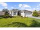Single-story home with gray roof, white garage door, and manicured lawn at 5207 Pine Shadow Ln, North Port, FL 34287