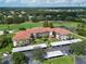 Stunning aerial view of the condo building, carport, golf course, and pond in a lush, green setting, creating a serene environment at 6503 Stone River Rd # 302, Bradenton, FL 34203