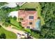 An aerial view of a home with a terracotta tile roof, pool, solar panels, and lush landscaping at 9915 Old Hyde Park Pl, Bradenton, FL 34202