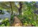 Landscaped backyard with lush greenery, stone pathway, and unique garden art at 1884 Grove St, Sarasota, FL 34239