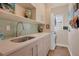 Modern laundry room with washer, dryer, and a built-in sink at 1884 Grove St, Sarasota, FL 34239