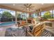 Relaxing outdoor kitchen with seating area, grill, fireplace and pool view at 14619 Leopard Creek Pl, Lakewood Ranch, FL 34202