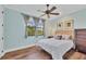 Spacious bedroom with a queen bed, light blue walls, and hardwood floors at 14619 Leopard Creek Pl, Lakewood Ranch, FL 34202