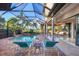 Inviting pool area with screened enclosure, spa, and outdoor kitchen at 14619 Leopard Creek Pl, Lakewood Ranch, FL 34202