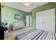 Bedroom with green walls, a bed, dresser, and a large TV at 14607 Swiss Bridge Dr, Lithia, FL 33547