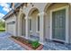 Inviting front entrance with arched entryway, gray door, and landscaping at 14607 Swiss Bridge Dr, Lithia, FL 33547