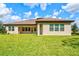 Tan house exterior with tile roof and covered patio at 14607 Swiss Bridge Dr, Lithia, FL 33547