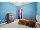 Bright bedroom featuring blue walls, a full-size bed, and a dresser at 14607 Swiss Bridge Dr, Lithia, FL 33547