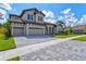 Two-story house with tan exterior, three car garage, and paved driveway at 14607 Swiss Bridge Dr, Lithia, FL 33547