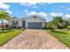 Modern house exterior with gray garage door and paver driveway at 7434 35Th E Ln, Sarasota, FL 34243