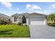 One-story home with gray driveway and landscaping at 5207 Pine Shadow Ln, North Port, FL 34287