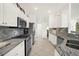 Modern kitchen with granite counters, stainless steel appliances, and white cabinets at 5207 Pine Shadow Ln, North Port, FL 34287