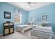 Light blue bedroom with twin beds, a dresser, and a window at 5207 Pine Shadow Ln, North Port, FL 34287