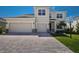 Charming two-story home featuring a paved driveway, a two-car garage, and manicured landscaping at 4322 Silo Port Ct, Lakewood Ranch, FL 34211