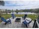 Lake view from backyard with Adirondack chairs and fire pit offer relaxation and peaceful ambiance in outdoor space at 4629 Sabal Key Dr # 4629, Bradenton, FL 34203