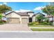 Beautifully landscaped home with a tile roof, three-car garage and a paver driveway at 7020 Whittlebury Trl, Lakewood Ranch, FL 34202