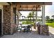 Inviting covered patio with stone accents, a built-in grill, and outdoor dining area at 7020 Whittlebury Trl, Lakewood Ranch, FL 34202