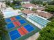 Aerial view of condo community amenities, including tennis and shuffleboard courts and pool at 752 White Pine Tree Rd # 206, Venice, FL 34285