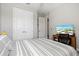 Bedroom with striped bedding, desk, chair, and double doors to closet at 904 Whimbrel Run, Bradenton, FL 34212