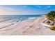 Aerial of beach showing waves, white sand, and beach chairs at 904 Whimbrel Run, Bradenton, FL 34212