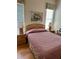 Second bedroom with hardwood floors, double bed, and window coverings at 5658 Downham Meadows, Sarasota, FL 34235